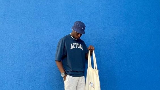 Ein Mann mit einem perfekten Vintage Outfit. Dazu passende Schuhe, einen Hut und ein Vintage T-Shirt aus unserem Shop.